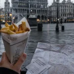 Bruxelles activités : cornet de frites et plan de Bruxelles sur pavé mouillé
